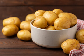 Young potatoes. Fresh potatoes  on a wooden background.Harvesting collection. organic, freshly dug potatoes. Agricultural background. Vegan. Vegetables.Place for text.Copy space