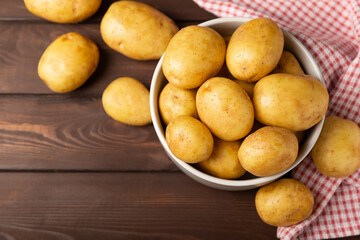 Young potatoes. Fresh potatoes  on a wooden background.Harvesting collection. organic, freshly dug potatoes. Agricultural background. Vegan. Vegetables.Place for text.Copy space