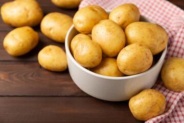 Young potatoes. Fresh potatoes  on a wooden background.Harvesting collection. organic, freshly dug potatoes. Agricultural background. Vegan. Vegetables.Place for text.Copy space