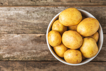 Young potatoes. Fresh potatoes  on a wooden background.Harvesting collection. organic, freshly dug potatoes. Agricultural background. Vegan. Vegetables.Place for text.Copy space
