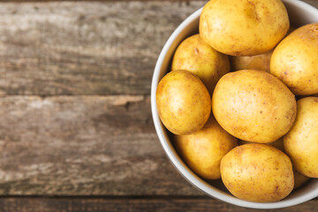 Young potatoes. Fresh potatoes  on a wooden background.Harvesting collection. organic, freshly dug potatoes. Agricultural background. Vegan. Vegetables.Place for text.Copy space
