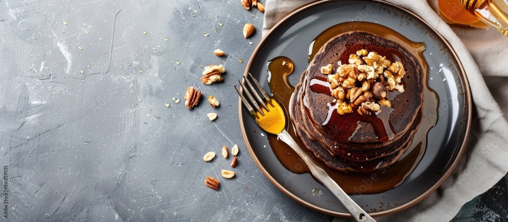 Poster delicious healthy breakfast snack featuring chocolate pancakes topped with honey and nuts on a plate