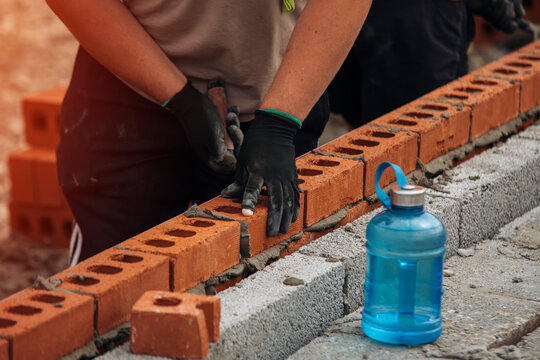 Bricklaying Construction Worker Wearing Gloves During the Day