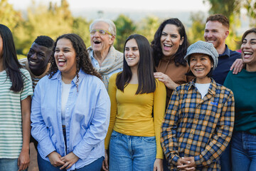 Crowd of multi generational people having fun together outdoor - Multiracial friends enjoy day at city park together - Community concept