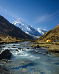 Fototapeta premium Serene Mountain Campsite with Tents by a Clear River, Nestled in Snow-Capped Valley at Daytime