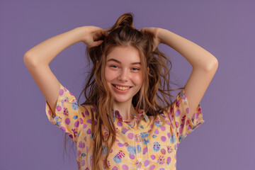 Fototapeta premium Portrait of a cheerful young girl in a floral shirt, touching her hair, set against a vibrant purple background, perfect for lifestyle and fashion content.