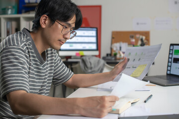 Male Asian graphic designer working in an office studio, designing logos and showcasing the corporate identity and logo design process.