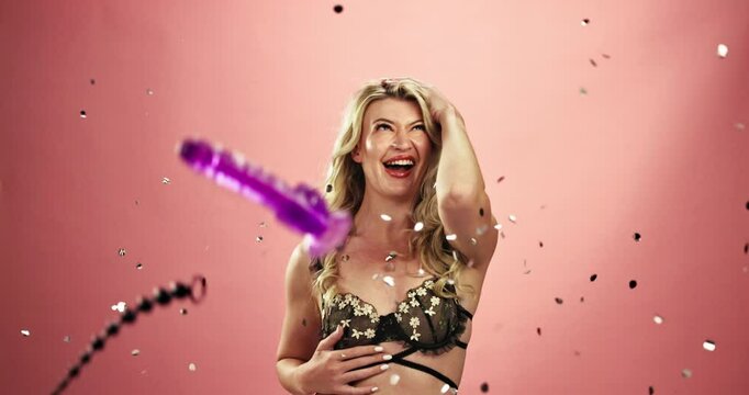 Excited woman, lingerie and celebration with sex toys, confetti or glitter on a studio background. Portrait of female person, model or adult with underwear for sexual, erotic or sensual pleasure
