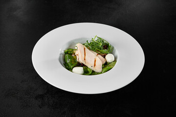 Fresh Chicken Fillet and Mozzarella Salad with Greens on Black Background