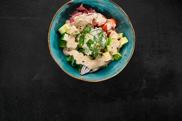 Fresh Tuna Poke Bowl with Avocado and Vegetables on Dark Background