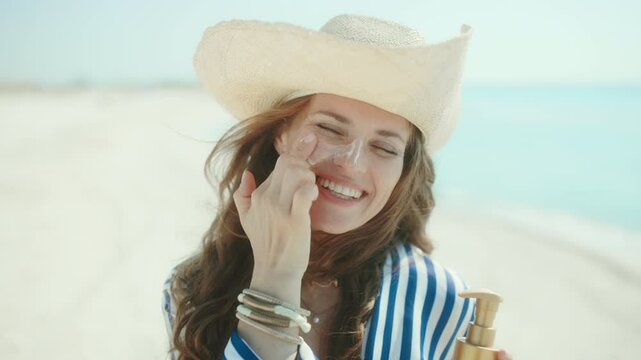 smiling modern female on the beach with spf.