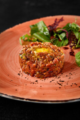 Beef Tartare with Quail Egg and Fresh Salad Mix on Elegant Plate