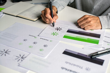 Close-up shot of a graphic designer making notes on logo designs and showcasing the corporate identity and logo design process.