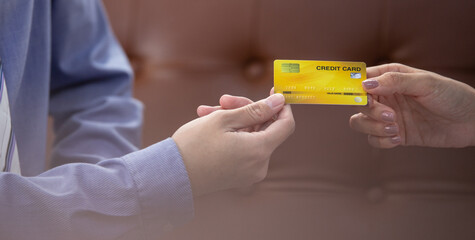 Close up hand of customer giving credit card to sales, agent or dealer for purchasing product