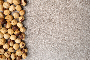 Roasted hazelnuts on a gray stone background top view, place for text