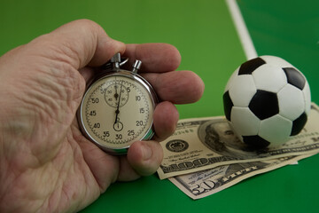 stopwatch in hand and dollars with soccer ball on green background, bookmaker odds, betting odds, sports betting, soccer posters, betting times