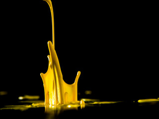 Colorful paint jumping in different forms in front of black background.