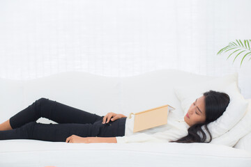 Young asian woman peaceful sleeping on sofa in living room at home, woman nap while reading book on couch with cozy at home, relax and comfort, exhausted and sleep, lifestyle concept.
