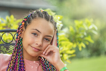 Portrait of beautiful young girl with colorful braids in her hair  closeup.. Horizontally. 