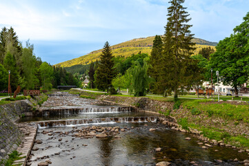 Obraz premium Elbe (Lave) river flowing through the city centre of Spindleruv Mlyn - popular tourist hiking destination and winter ski resort. Krkonose Mountains