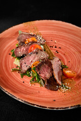 Roast Beef with Tomatoes and Arugula on Rustic Plate - Gourmet Meat Dish