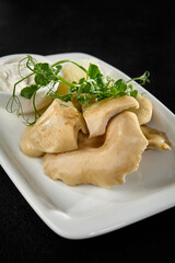 Salted Milk Cap Mushrooms with Sour Cream on a White Plate