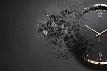 Black clock shattering into pieces on black background. Flow of time