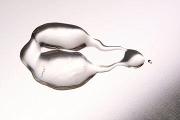 A smear of cosmetic gel close-up on a gray background. Appetizing texture with bubbles.