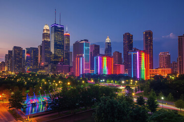 Fototapeta premium Modern city skyline is illuminated in rainbow colors for pride month, celebrating diversity and inclusion
