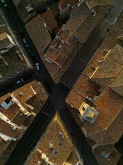 View of a European city with old tiled rooftops and intersecting narrow streets at sunset