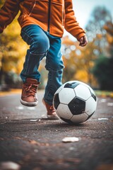 A close-up shot of a boy playing with soccer ball alone