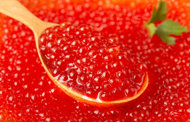 a lot of delicious red caviar in a wooden spoon