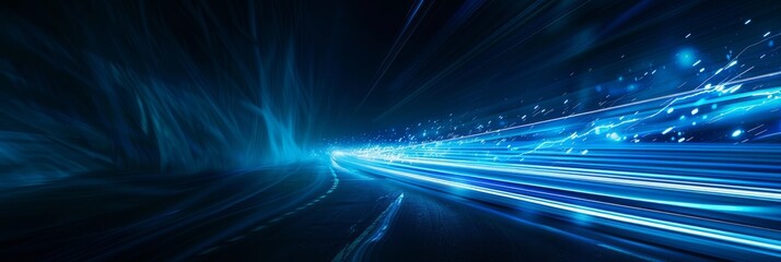 A high-angle photograph of blue light streaks racing across a dark background, creating a futuristic and dynamic image