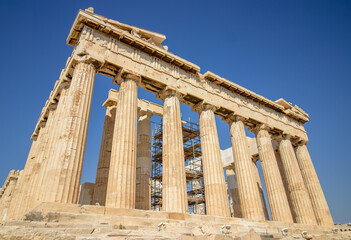 Obraz premium Ancient Parthenon Temple on top of the Acropolis Athens, Greece at sunny day with a blue sky. The landmark of Athens. Parthenon is the temple of for dedication to the goddess Athena.
