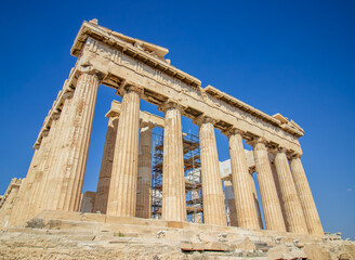 Obraz premium Ancient Parthenon Temple on top of the Acropolis Athens, Greece at sunny day with a blue sky. The landmark of Athens. Parthenon is the temple of for dedication to the goddess Athena.
