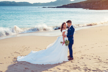 Husband and wife on a beach near the ocean