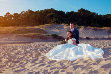 Husband and wife on a beach near the ocean
