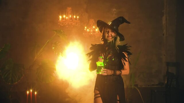 Fantasy woman witch in dark gothic room full smoke magic light sexy witch girl holding bottle glowing green liquid potion magical drink. Lady Halloween Costume Black dress Hat art video footage 4k