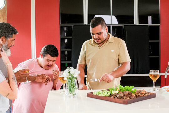 Boy with mental disability eating barbecue and having fun with his family.