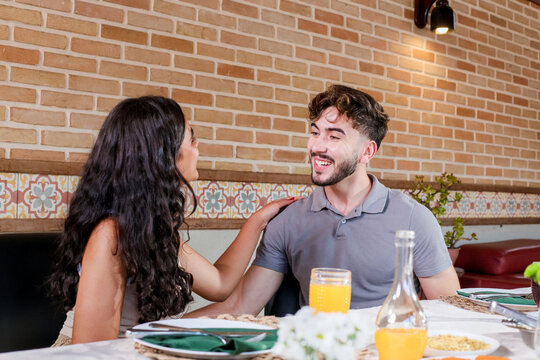 Adorable couple talking sitting at the table enjoying lunch together.
