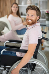 Obraz premium cheerful woman lying on sofa with disabled man