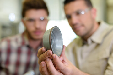 close view of metal component held by male engineer