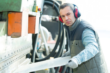 factory man worker holding metal sheet in workshop