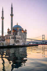 Naklejka premium A long exposure of the Ortakoy Mosque in Istanbul early in the morning with a container ship moving in the background