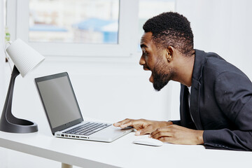 Businessman in shock while working on laptop at desk