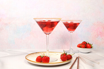 Festive alcoholic cocktail, red martini in glasses on a bright background with strawberries, summer bar concept, alcoholic drinks at a party, restaurant and cafe advertising, selective focus.