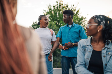 Diverse college students discussing at university campus during break.