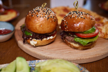 Delicious Gourmet Burgers beautifully presented on a Wooden Board at a Restaurant