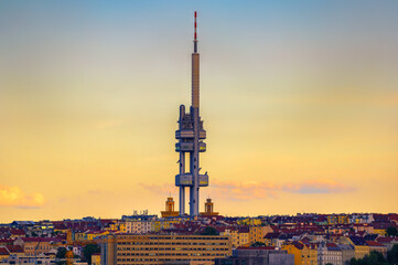 Obraz premium The Zizkov Television Tower in Prague at sunset. Zizkov Television Tower, completed in 1992, is a 216-meter tall broadcast tower, known for its unique design and panoramic views of the city.