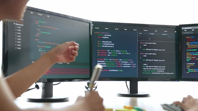 Slow motion back end software developer engineer for computer programming working together on debugging writing computing code, solving complex algorithms display on monitor in office. Burgeoning